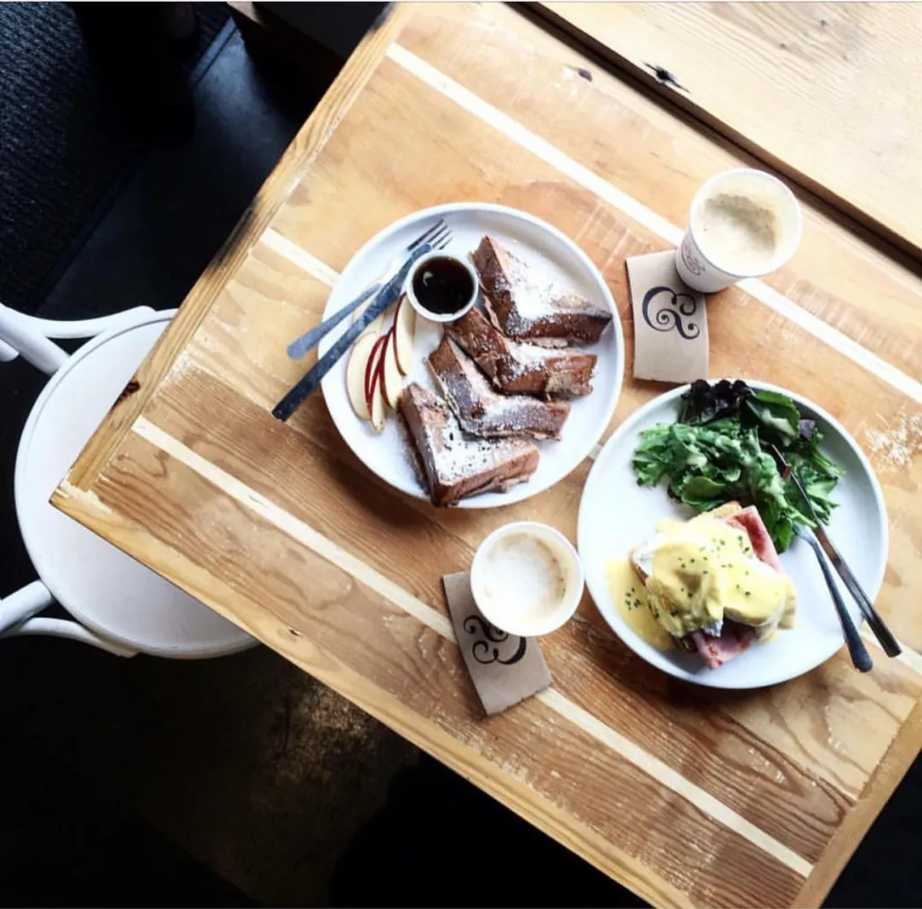 Breakfast plates of French toast and eggs on a wooden table