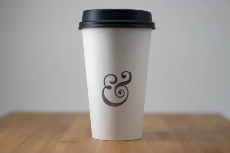 An &grain coffee cup on a wooden table